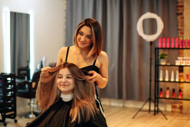 Profesyonel kadın kuaför. Güzellik salonunda çalışırken kadın saçına boya sürüyor.