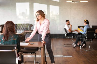 Gülümseyen çeşitli meslektaşlar mali istatistikleri tartışmak için toplantı odasında toplandılar. Mutlu iş arkadaşları iş birliği yapıyor ve ofis toplantısında birlikte çalışıyorlar. Takım çalışması kavramı.