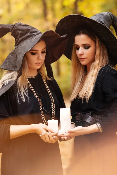 Zwei Junge Frauen Hexenkostüm Und Hut Blicken Geheimnisvoll Auf Kerzen — Stockfoto