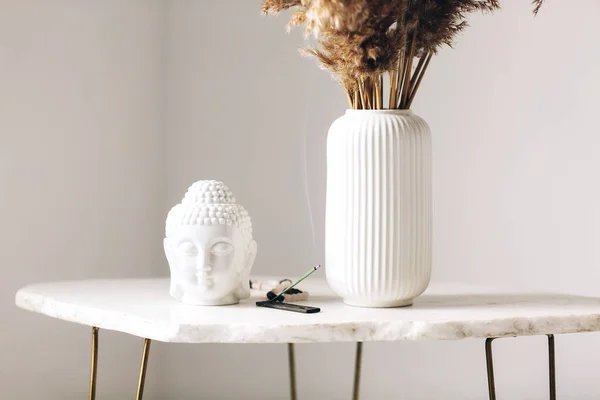 装飾が施された小さな大理石のテーブル 乾燥した花の白い花瓶 小さな仏像と現代的なシンプルなアパートメント環境でスタンドに焼香棒 — ストック写真