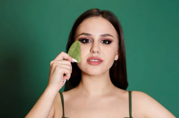 Jovem Atraente Segurando Pedra Sha Gua Verde Lado Seu Rosto — Fotografia de Stock