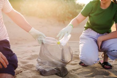 Gönüllüler plajda çöp, plastik çöp şişeleri ve maske topluyor. Ekoloji, çevre, kirlilik ve ekolojik sorunlar kavramı