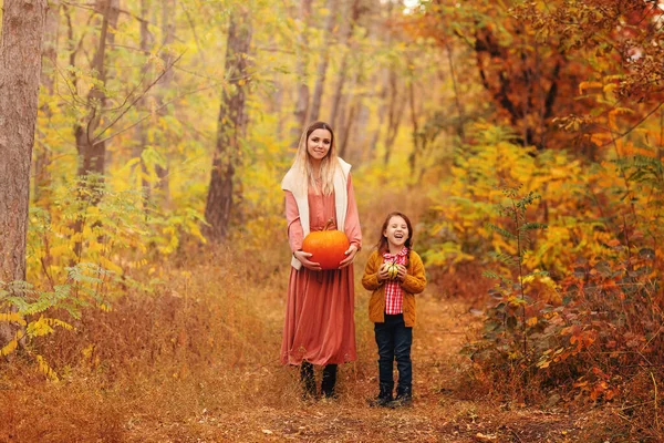 年轻的家庭 母亲和小儿子 在秋天的森林里散步 妈妈和孩子手牵着水泵 走在黄叶覆盖的小径上 在美丽的大自然中度过时光 — 图库照片