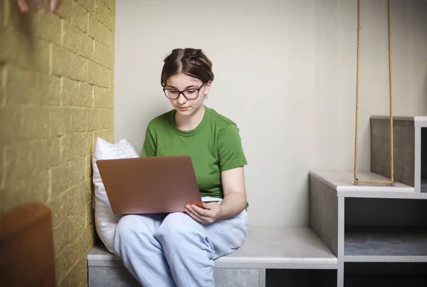 Adolescente Femenina Usando Netbook Mirando Hacia Otro Lado Mientras Relaja —  Fotos de Stock