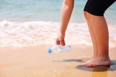 Gönüllü, plajda çöp, plastik çöp şişeleri ve maske topluyor. Ekoloji, çevre, kirlilik ve ekolojik sorunlar kavramı