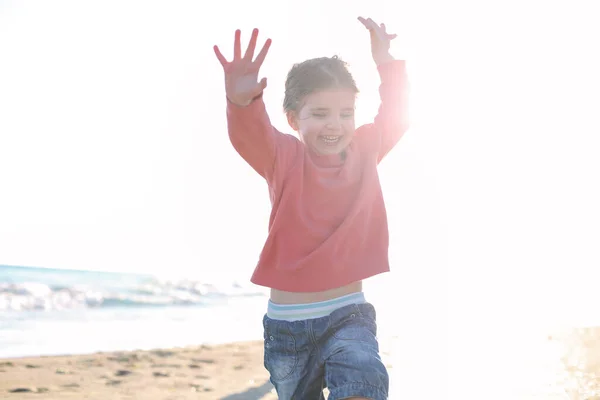 かわいい笑顔の女の子は日当たりの良いビーチで実行しています 幸せな女の子 夏の海辺で過ごす時間を楽しんで — ストック写真