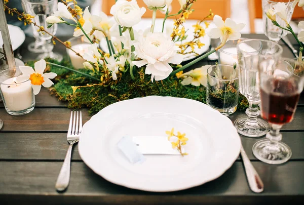 Çeşitli yemek ve içeceklerin arasına taze çiçekler konulmuş. Ziyafet sırasında insanların yanında.