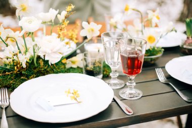 Çeşitli yemek ve içeceklerin arasına taze çiçekler konulmuş. Ziyafet sırasında insanların yanında.