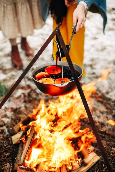 田舎で冬に燃える丸太の上に鍋にオレンジの準備のスライスと伝統的なマルチワインの上から — ストック写真