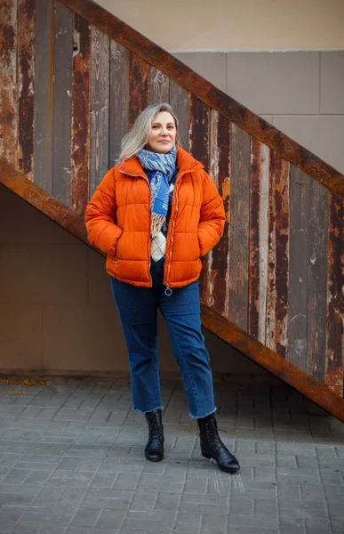 Glad Positiv Medelålders Kvinna Orange Dunjacka Ler Mot Kameran Medan — Stockfoto