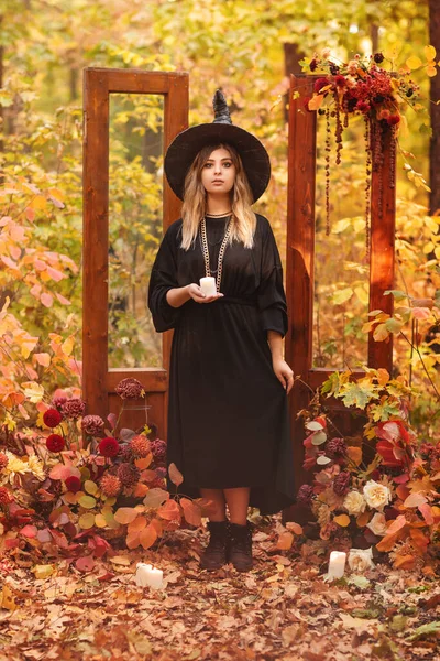 Ung Kvinna Häxdräkt Och Hatt Tittar Mystiskt Ljus Händerna Isolerad — Stockfoto