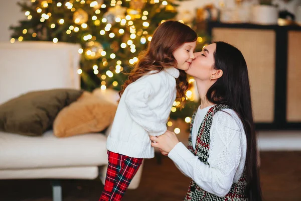 Bela Mãe Amorosa Beijando Suavemente Filhinha Fofa Contra Árvore Natal — Fotografia de Stock