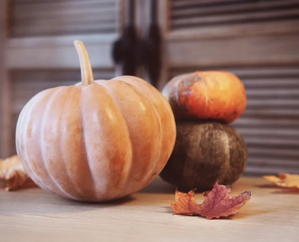 Zucche autunnali con foglie sul tavolo di legno — Foto Stock