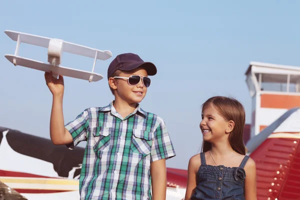 Маленький хлопчик і дівчинка-пілот з літаком ручної роботи — стокове фото