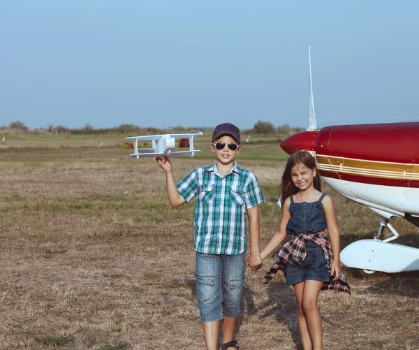 Petit garçon et petite fille pilote avec avion fait main — Photo