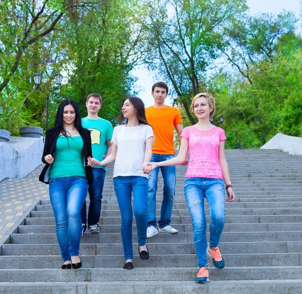 Smiling group of teenagers walking outdoors — Stock Photo, Image