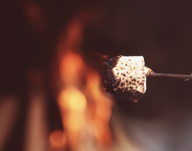 Close up of a marshmallow on a stick being roasted  clipart