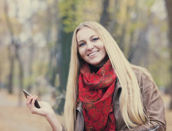 Portrait of a smiling beautiful woman texting sms — Stock Photo, Image