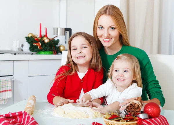 Zwei entzückende Mädchen mit Mutter beim Backen von Weihnachtsplätzchen in der k — Stockfoto