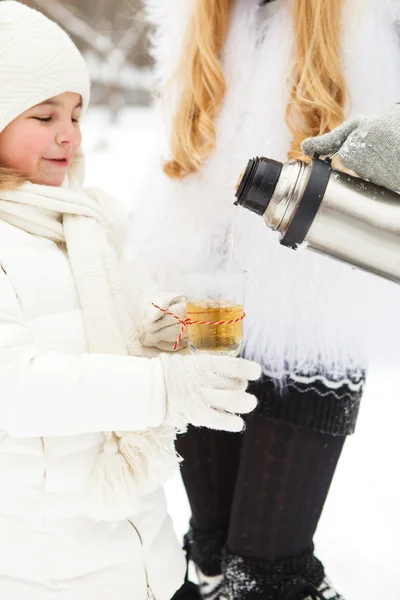 Lykkelig ung mor med datter på vinterpiknik – stockfoto