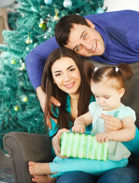 Familia con regalo de Navidad cerca del árbol de Navidad — Foto de Stock