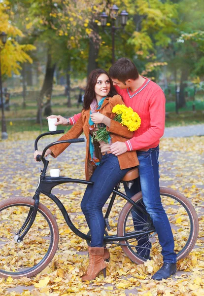 Casal feliz com bicicleta no parque de outono — Fotografia de Stock