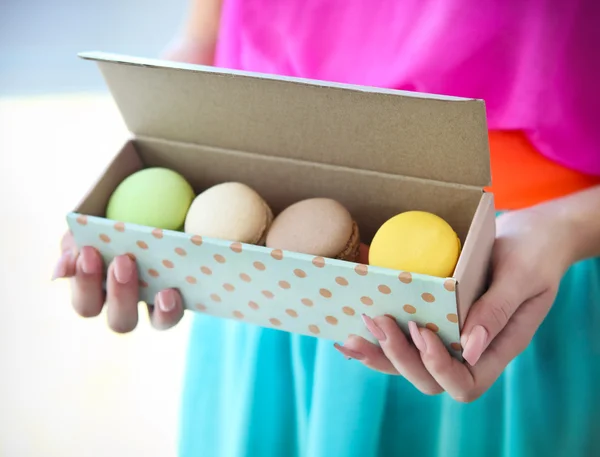 Flicka håller färgglada franska macaroons i händer — Stockfoto