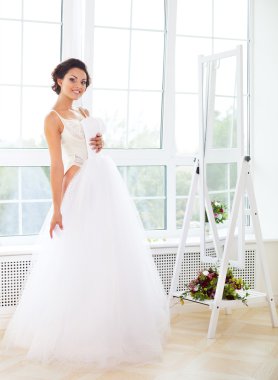 Beautiful bride-to-be trying her dress in shop clipart