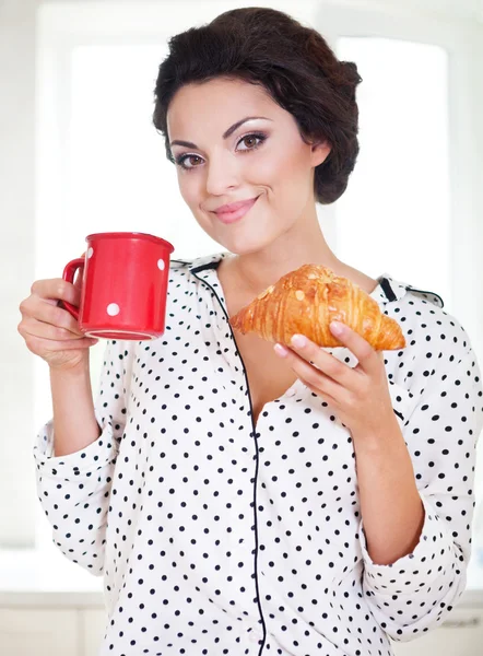 Mujer feliz sosteniendo una taza de café y croissant —  Fotos de Stock