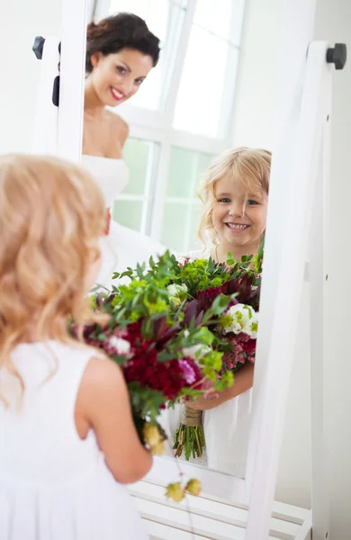 Sonriente novia feliz y una niña de flores en el interior —  Fotos de Stock