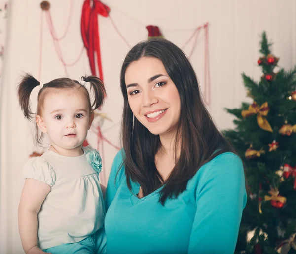 Madre feliz con hija cerca del árbol de Navidad — Foto de Stock