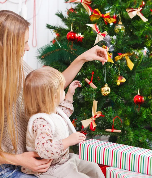 Mère heureuse et sa fille décorant un arbre de Noël — Photo