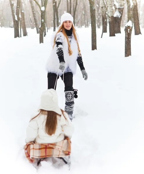 小女孩开心上雪橇与她的母亲 — 图库照片