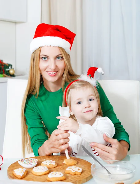 Adorable little girl with her mother baking Christmas cookies — Stock Photo, Image