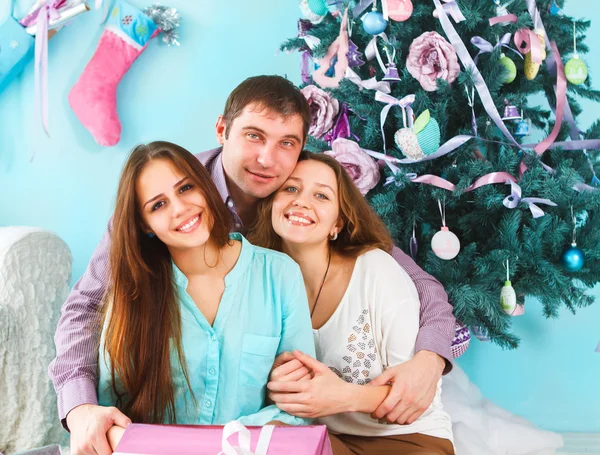 Семья держит рождественские подарки и сидит на полу — стоковое фото