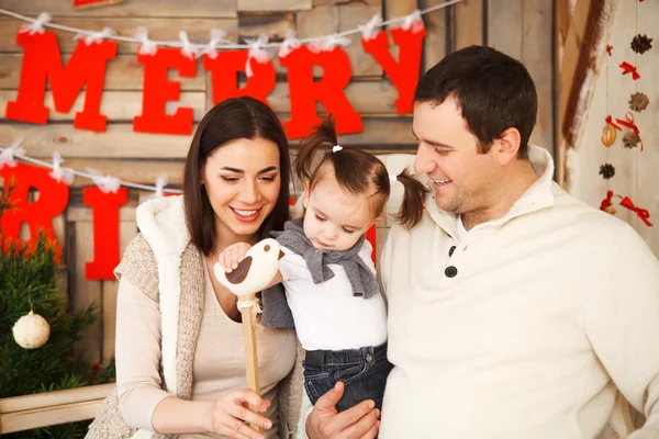 Familia con una hija de un año cerca del fondo de Navidad —  Fotos de Stock