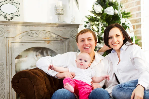 Щаслива сім'я з новорічною дитиною біля ялинки — стокове фото