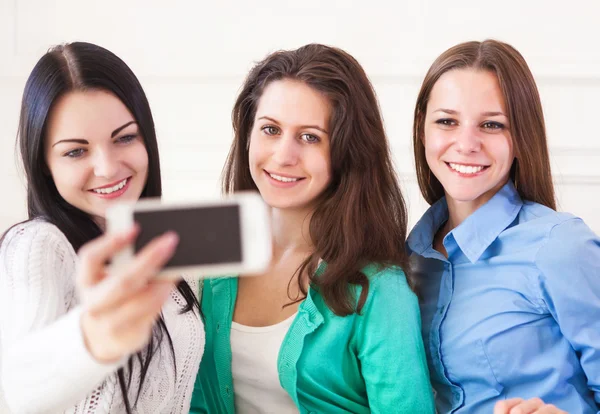 Three smiling teenage girls taking selfie with smartphone camera Stock Picture