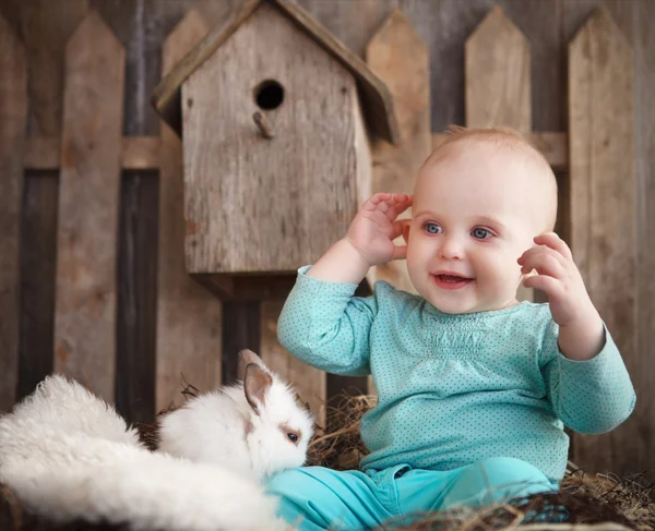 Portret van een schattige babymeisje en kleine witte konijn — Stockfoto