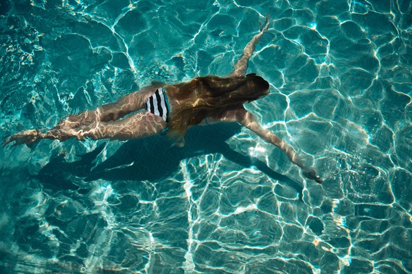 Mujer nadando en una piscina de agua azul —  Fotos de Stock