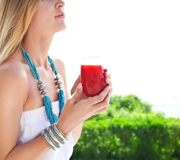 Vrouw met glas van een aardbei sap — Stockfoto