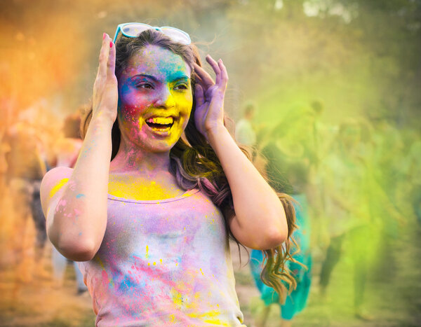 Счастливая молодая девушка на празднике цвета холи