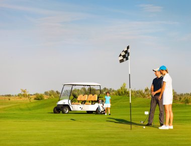 Sportif aile bir golf sahasında golf oynamak