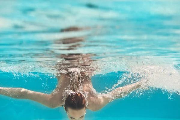 Natación mujer joven bajo el agua en la piscina — Foto de Stock