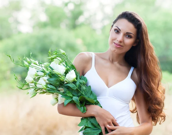 Bella donna in campo con fiori — Foto Stock