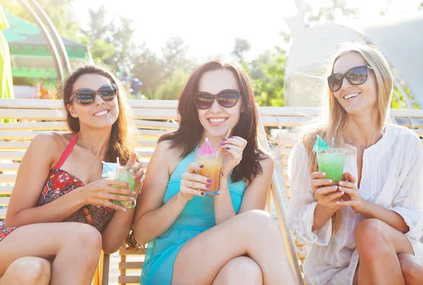 Щасливі дівчата з напоями біля басейну — стокове фото