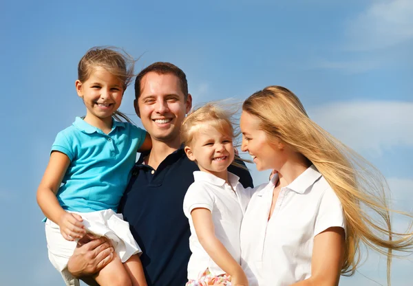 Jovem família feliz com duas crianças ao ar livre — Fotografia de Stock