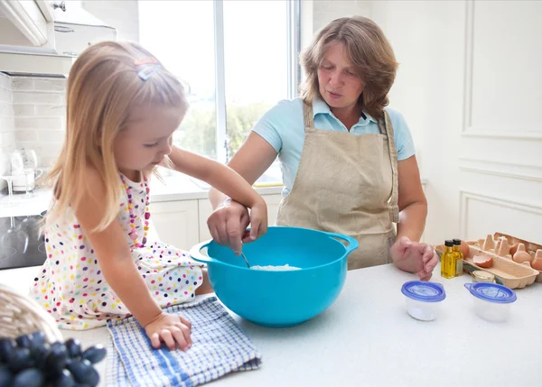 Petite fille cuisiner avec sa grand-mère à la maison — Photo