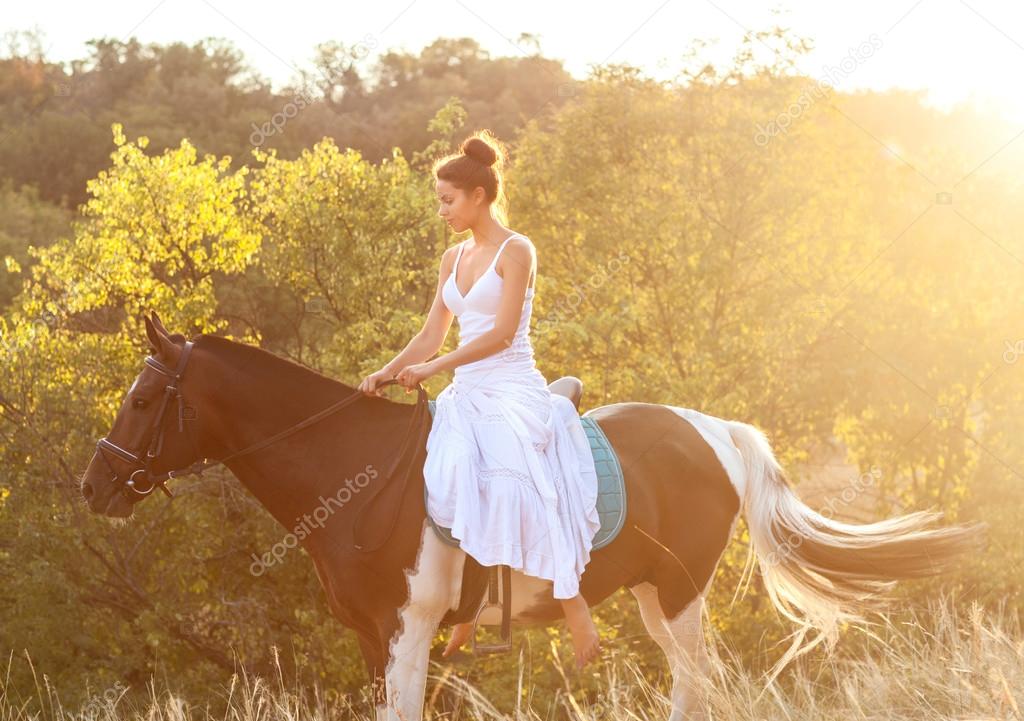 Beautiful woman riding on a horse