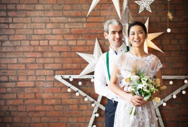 Güzel çift ayakta tuğla duvarın yanında evli 